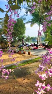 a group of people sitting in a park with flowers at Ambadi's villa -Lake view resort in Pallipuram