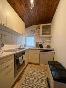kuchnia z białymi urządzeniami i drewnianym sufitem w obiekcie Liboria: lovely,cosy apartment. 2 min skilift walk w mieście Campitello di Fassa