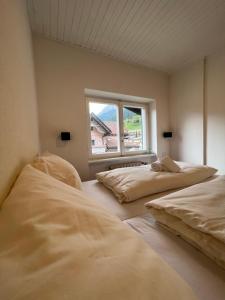 dwa łóżka w pokoju z oknem w obiekcie Liboria: lovely,cosy apartment. 2 min skilift walk w mieście Campitello di Fassa