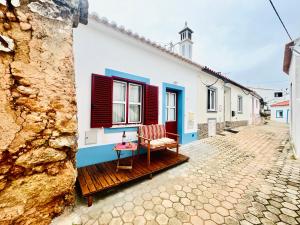 ein Haus mit roten und blauen Rollläden auf einer Straße in der Unterkunft CASA BIKAS in Barão de São Miguel + 20 Fotos