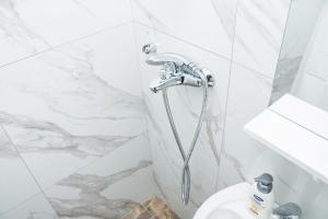 a shower in a white bathroom with a toilet at APARTMANI Arsic in Jahorina +91 photos