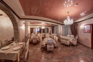 a dining room with tables and chairs and a chandelier at Mountain Krystal in Bukovel