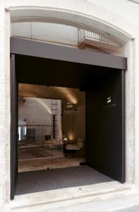 eine Tür zu einem Gebäude mit einem großen Glasfenster in der Unterkunft Le Carasse Boutique Hotel in Mola di Bari