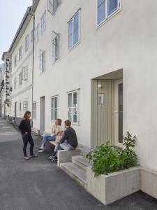 un gruppo di persone seduti sui gradini di un edificio di STILVOLL und LUFTIG IM HERZEN VON LINZ a Linz