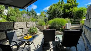 een patio met een tafel en stoelen en een stenen muur bij Black Forest Villa in Lahr