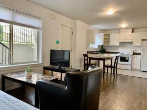 a kitchen and living room with a table and chairs at Spacious Burnaby Guest Home in Burnaby
