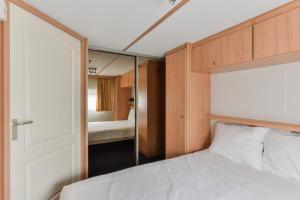 een slaapkamer met een bed en een spiegel bij CHALET FOR 2 AT THE BEACH in Zandvoort