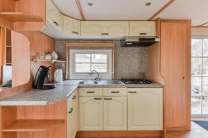 a kitchen with white cabinets and a sink at CHALET FOR 2 AT THE BEACH in Zandvoort