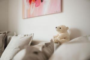 un ours en peluche assis sur un canapé dans l'établissement White Apartment, à Ljubljana