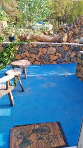 two benches sitting next to a stone wall at Finca Cosmos in El Paso