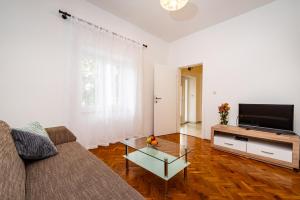 a living room with a couch and a tv at Apartment Eva in Maslenica