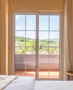 una camera da letto con una grande porta a vetri che conduce a un balcone di Rozmarine a Pëllumbas