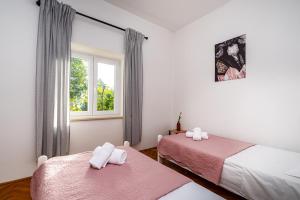 a bedroom with two beds and a window at Apartment Eva in Maslenica
