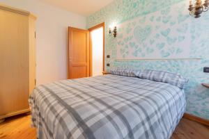 a bedroom with a bed with a blue and white bedspread at Patrioti 51 - Asiago Centro in Asiago