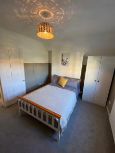 - une chambre avec un lit et un lustre dans l'établissement Stylish 2 bedroom cottage, close to town centre, à Worthing