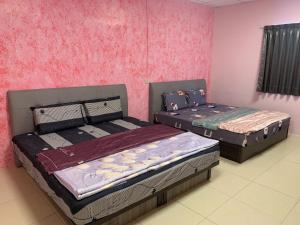 枋寮鄉的住宿－訪寮民宿，配有粉红色墙壁的客房内的两张床