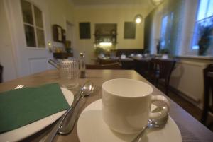 グロースグマインにあるGästehaus Waldeckの木製テーブルの上にコーヒーカップとスプーン