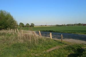 een hek aan de kant van een weg naast een veld bij FeWo Clemens - Wohnküche + 2 Schlafräume + Bad + Terrasse in Hamm