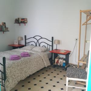 a bedroom with a bed and two tables and a chair at Ratones de Biblioteca in La Laguna