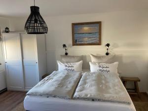 a bedroom with a bed with white sheets and pillows at Hafenkoje Zum Anker in Wolgast