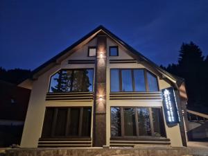 a house with lights on the front of it at Garnet Star Apartments, Kopaonik, apartman br 2 in Kopaonik