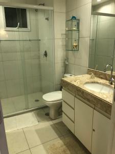 a bathroom with a toilet and a shower and a sink at Apto de luxo no Golfville Ideal para família e home office Prox do Beach Park in Aquiraz +8 photos