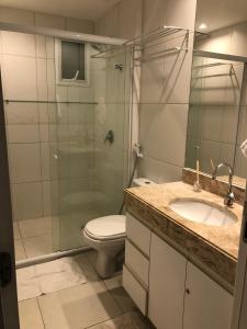 a bathroom with a shower and a toilet and a sink at Apto de luxo no Golfville Ideal para família e home office Prox do Beach Park in Aquiraz