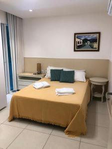 a bedroom with a bed with two towels on it at Apto de luxo no Golfville Ideal para família e home office Prox do Beach Park in Aquiraz