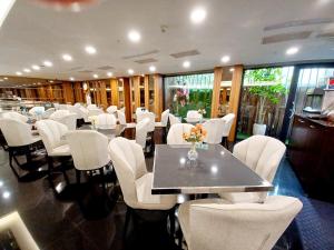 a dining room with white chairs and a table and tables and chairsktop at Sa-Yo Hotel - Pier 2 in Kaohsiung