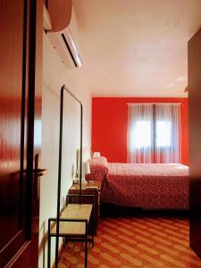 ein rotes Schlafzimmer mit einem Bett und einem Fenster in der Unterkunft Encantadora Boutique Home Villa Juan in Corme-Puerto