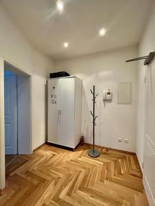 Pokój z białą lodówką i drewnianą podłogą. w obiekcie FirstClass 2R_Apartment in Leipzig w Lipsku