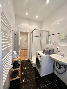 a bathroom with a washing machine and a sink at FirstClass 2R_Apartment in Leipzig in Leipzig