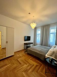 FirstClass 2R_Apartment in Leipzig في لايبزيغ: غرفة نوم بسرير وتلفزيون بشاشة مسطحة