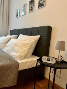 1 dormitorio con 1 cama y 1 mesa con reloj despertador en FirstClass 2R_Apartment in Leipzig, en Leipzig