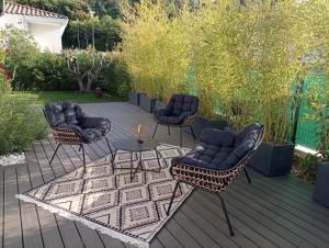 un patio avec des chaises et une table sur une terrasse dans l'établissement Villa contemporaine avec piscine dans un cadre verdoyant, à Calvisson