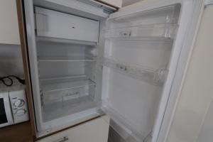 an empty refrigerator with its door open in a kitchen at Homeday FERME KLEIN in Haguenau