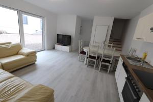 a living room with a couch and a table and a kitchen at Homeday FERME KLEIN in Haguenau