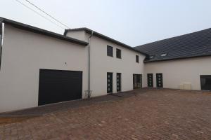a large white building with two garage doors at Homeday FERME KLEIN in Haguenau