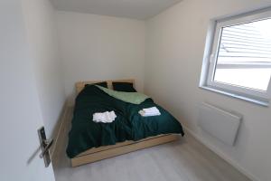 a small bed in a small room with a window at Homeday FERME KLEIN in Haguenau