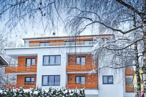 ein großes Gebäude mit Schnee an den Ästen eines Baumes in der Unterkunft Appartements Amarella in Bad Hofgastein
