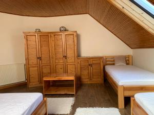 a bedroom with two twin beds and a wooden cabinet at Bolla Nyaralóház in Hegyhátszentjakab