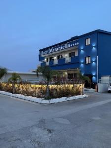 un bâtiment bleu avec un panneau qui lit l'hôtel sous une mascarade dans l'établissement Hotel Masaniello Luxury, à Casoria