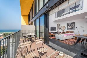 Super artist's apartment with parking في تل أبيب: شرفة مع كراسي وغرفة معيشة مع المحيط