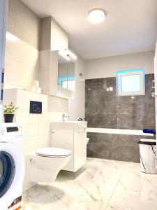 een witte badkamer met een toilet en een wastafel bij Hunyadi Luxury Kogalniceanu in Sibiu