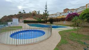a fence around two swimming pools in a yard at Villa Azur torrox costa in Torrox Costa