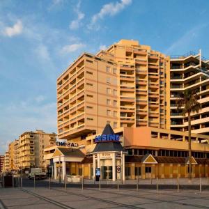 un grande edificio con un centro commerciale di fronte di Studio vue mer. Calme et idéalement situé a Canet-en-Roussillon