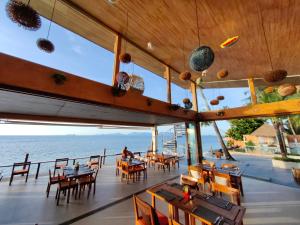 een restaurant met tafels en stoelen en uitzicht op de oceaan bij Mimosa Resort & Spa in Mae Nam