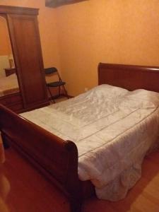 un letto con struttura in legno in una camera da letto di le repos du voyageur a Estadens Altre 19 foto