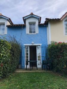 una casa azul con una mesa de ping pong delante de ella en Le Hameau du lac, en Marciac