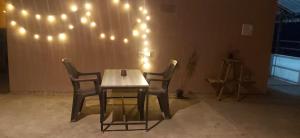 a table and two chairs with lights on the wall at Mcube stays in Sakleshpur